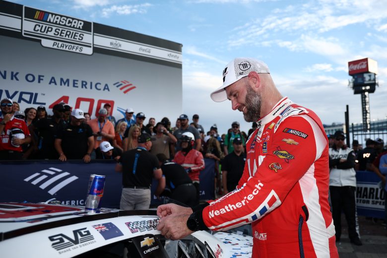 Shane van Gisbergen places sticker on car.