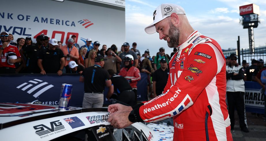 Shane van Gisbergen places winner sticker on car.
