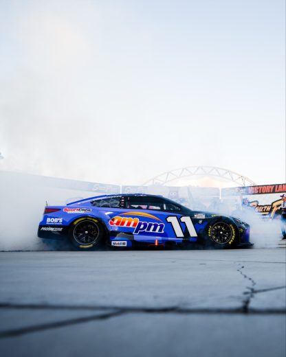 Denny Hamlin does a celebratory burnout in the No. 11 Joe Gibbs Racing Toyota.