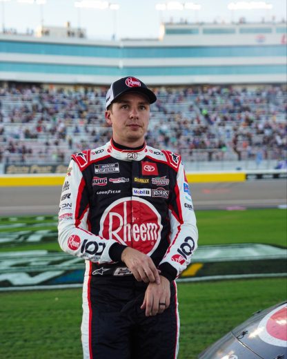 Christopher Bell looks on.
