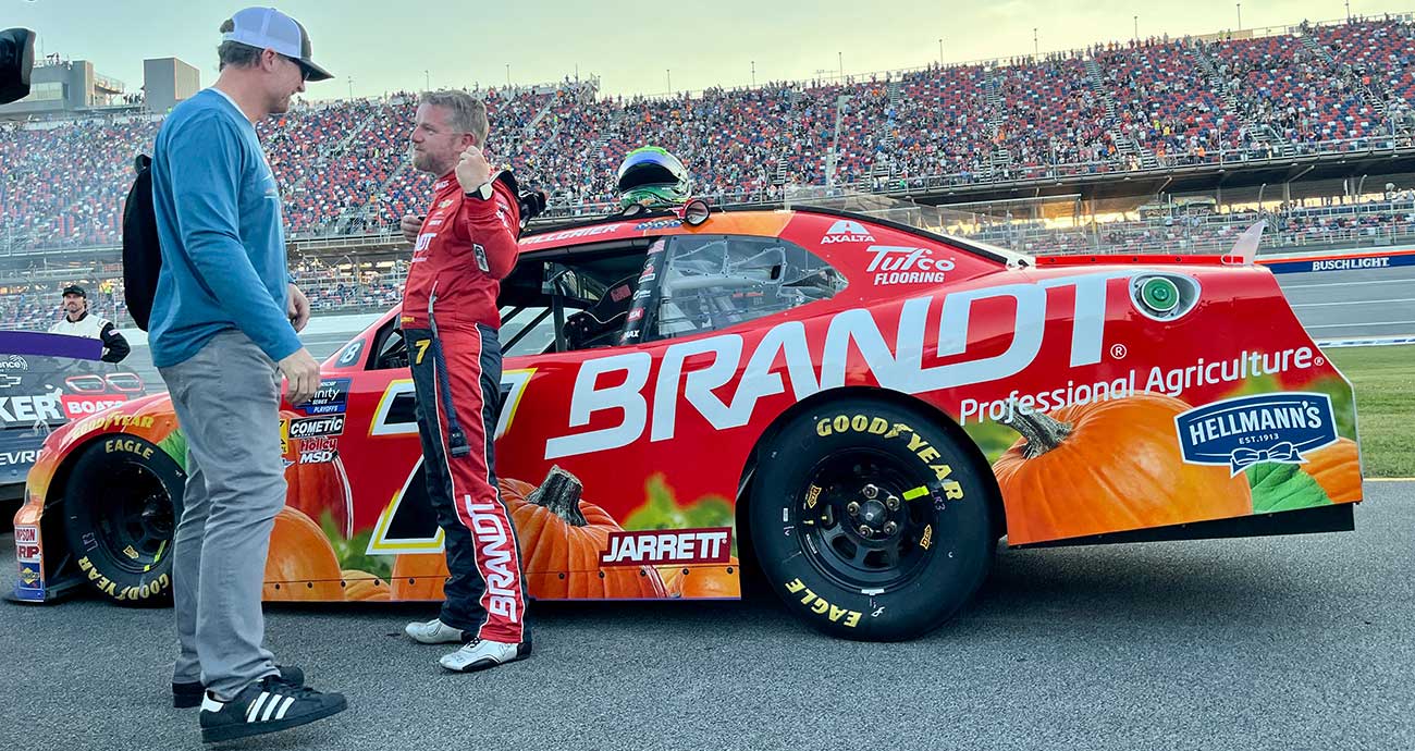Justin Allgaier emerges from his No. 7 Chevy and chats with JRM team owner Dale Earnhardt Jr. at Talladega Superspeedway