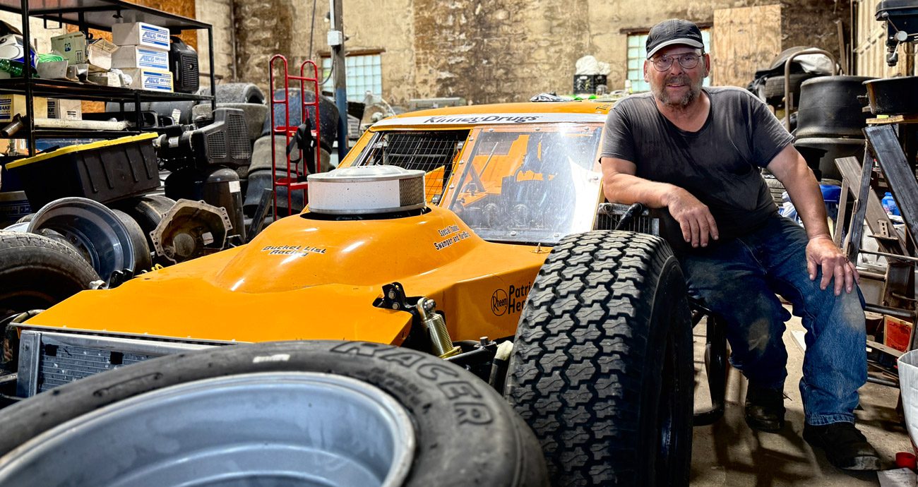 Billy 'Bondo' Clark sits next to a modified in Richie Evans' old shop.