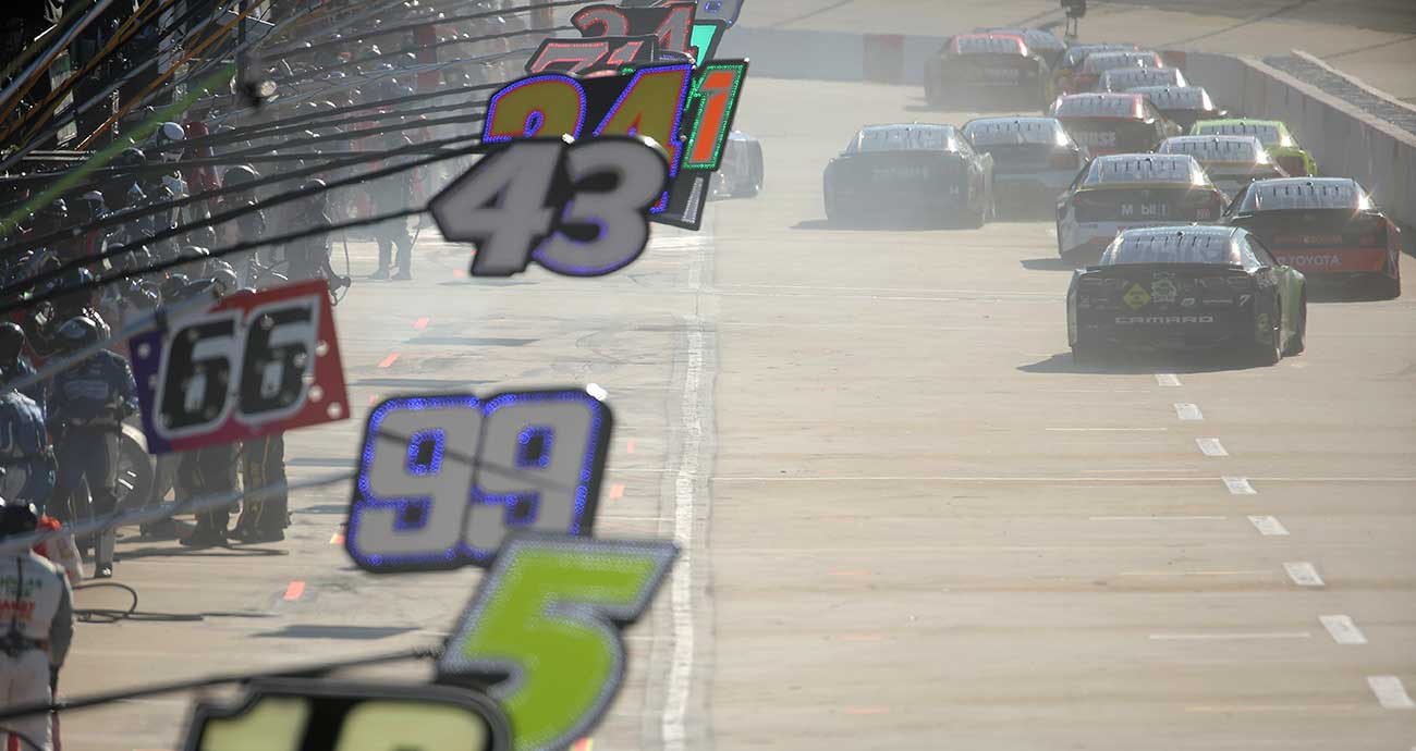 Cup Series cars depart pit road in a pack at Martinsville Speedway