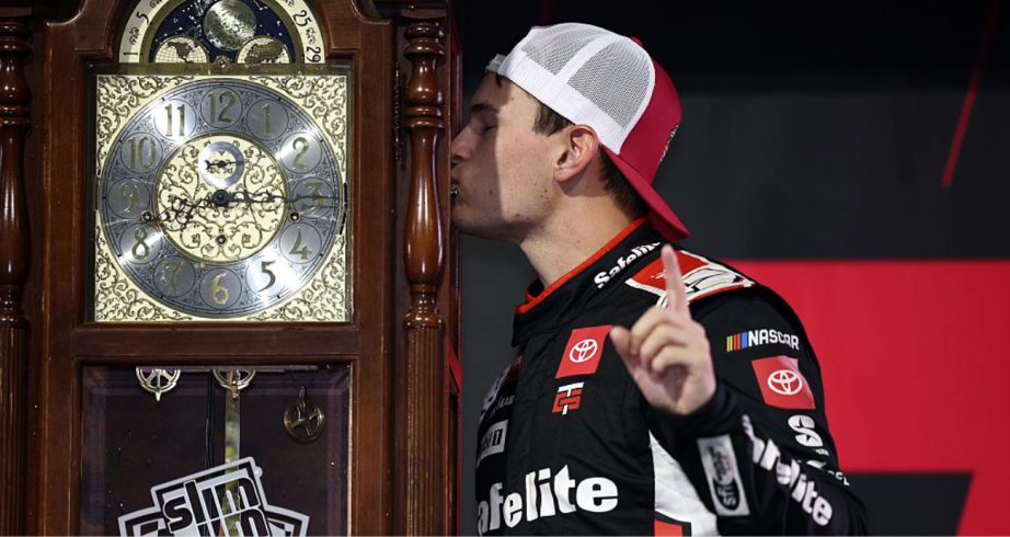 Corey Heim kisses the Grandfather Clock trophy at Martinsville.