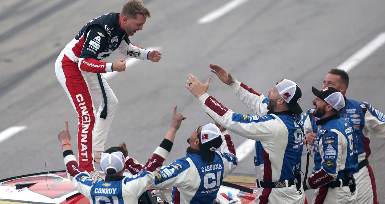 William Byron stands on top of his No. 24 Hendrick Motorsports Chevrolet and prepares to jump into the arms of his pit crew at Martinsville Speedway.