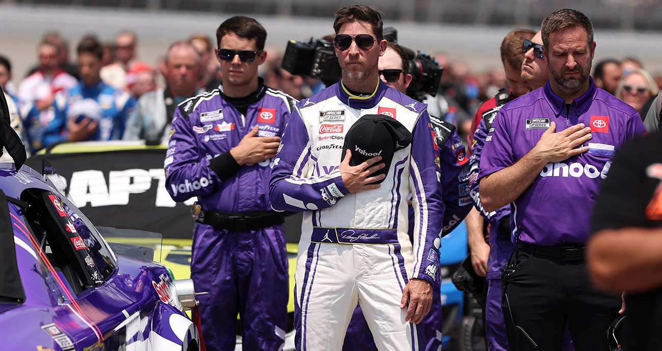 Chris Gayle, right, reflects during the National Anthem alongside driver Denny Hamlin at Michigan International Speedway