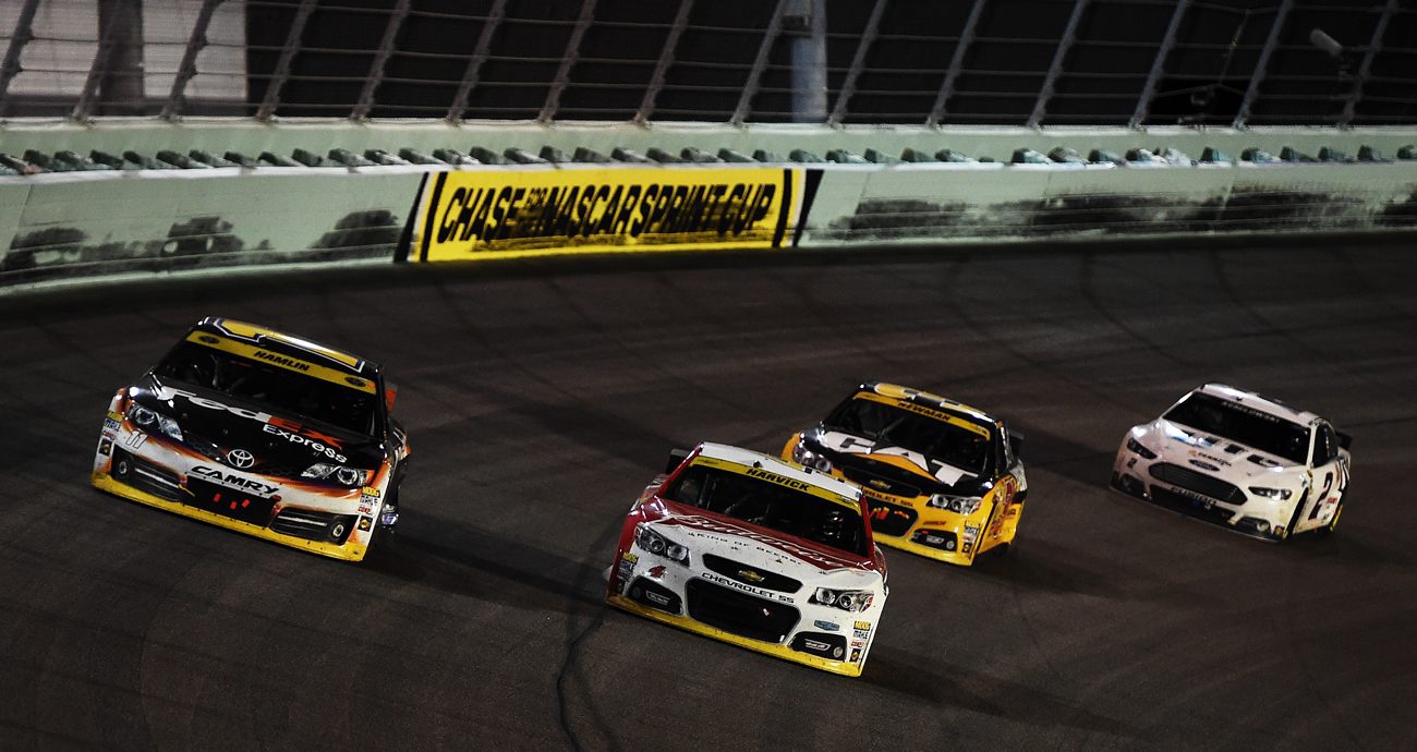 Kevin Harvick passes Denny Hamlin to take the lead and win the NASCAR Sprint Cup Series Ford EcoBoost 400 at Homestead-Miami Speedway on Nov. 16, 2014 in Homestead, Florida.