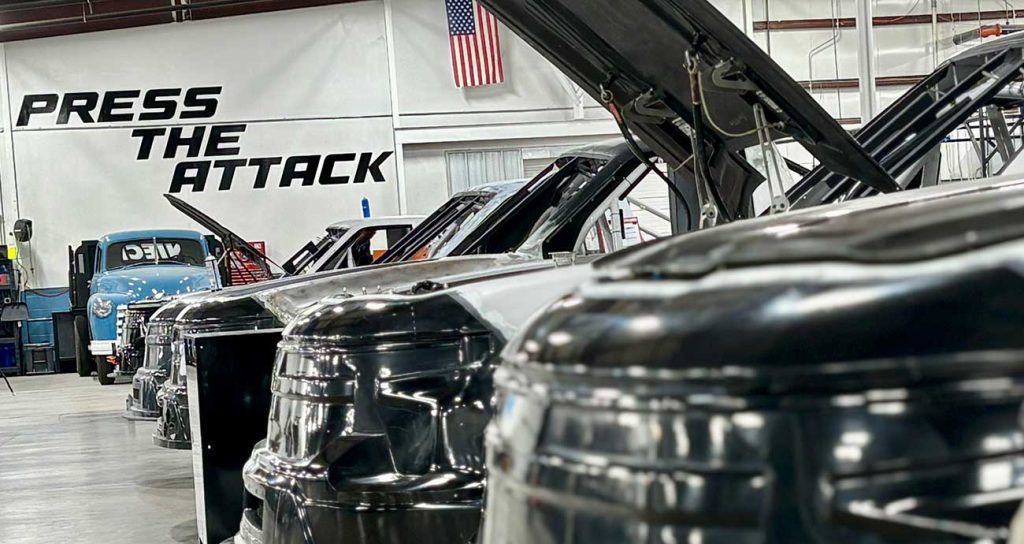 The "Press the Attack" motto appears over the busy shop floor at Niece Motorsports
