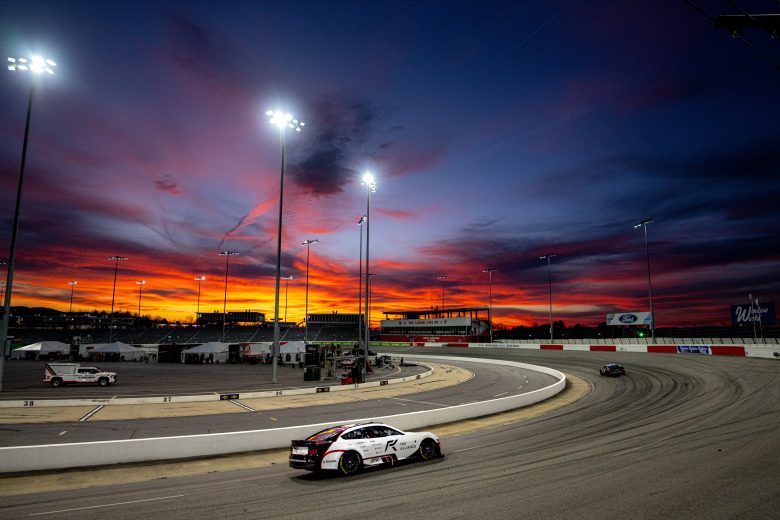 Chris Buescher drives No. 17 Ford at North Wilkesboro Speedway during sunset.