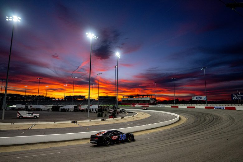Zane Smith drives No. 38 Ford at North Wilkesboro Speedway at sunset.