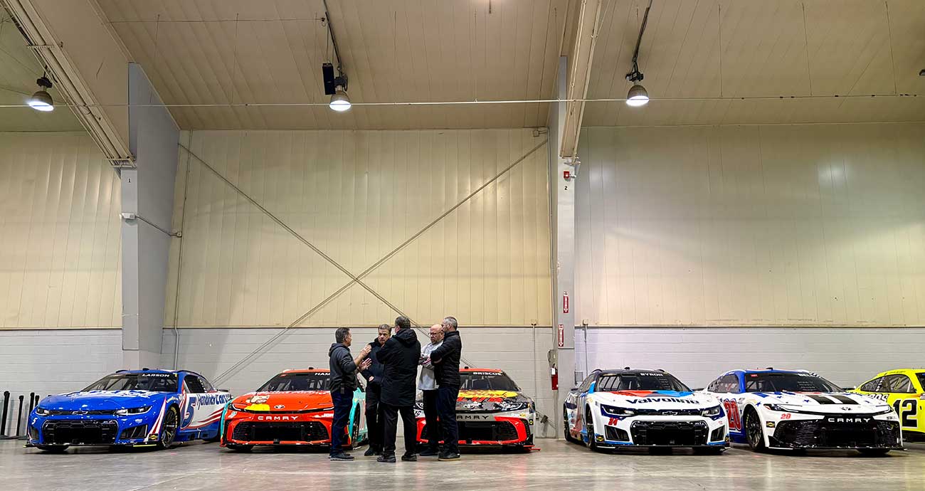 Cup Series cars line up after inspection in the Winston-Salem Fairgrounds events center