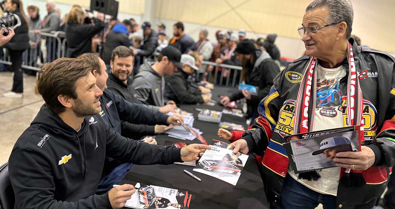 Daniel Suárez signs an autograph for a fan during the Clash Preview at the Winston-Salem Fairgrounds