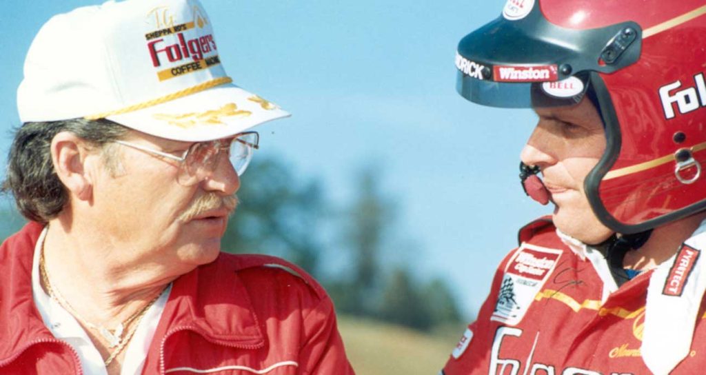 Team owner Rick Hendrick is suited up as he speaks with veteran crew chief Harry Hyde during the 1980s