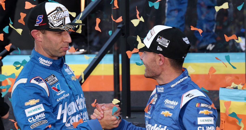 Cliff Daniels e Kyle Larson se cumprimentam com um aperto de mãos na Victory Lane após conquistarem o campeonato da NASCAR Cup Series de 2025.