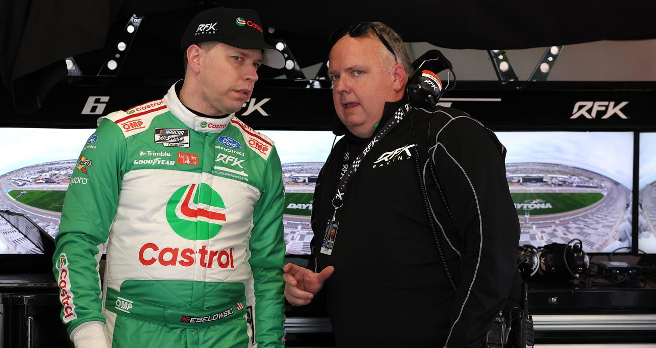 Brad Keselowski and crew chief Jeremy Bullins talk in the garage.