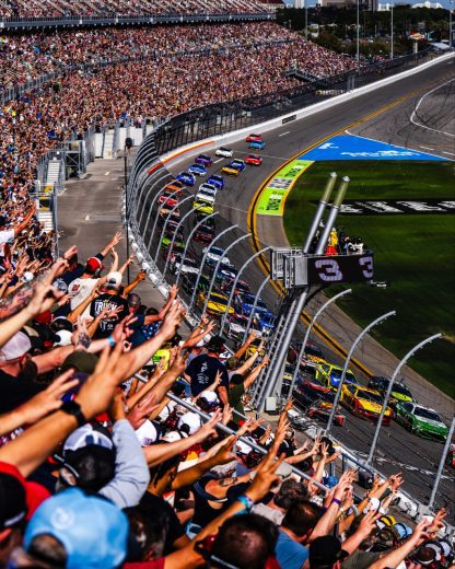 Fans salute to Dale Earnhardt by raising three fingers.