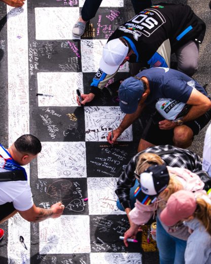 Fans write on the finish line at Daytona.