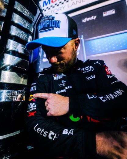 Tyler Reddick points to his name engraved on the Harley J. Earl Trophy.