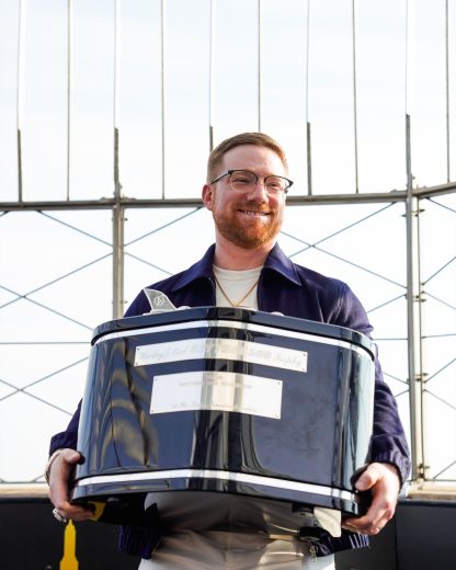 Tyler Reddick holds the Harley J. Earl Trophy.