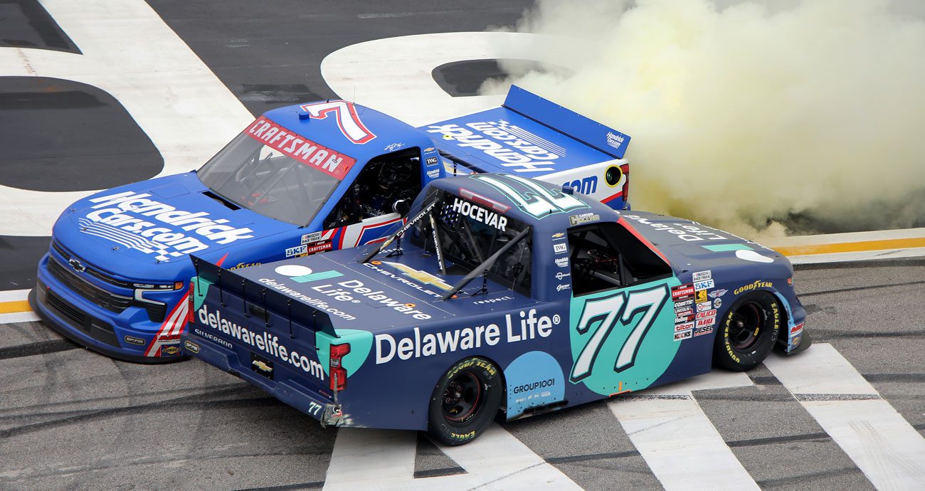 Kyle Busch and Carson Hocevar high-five each other after a Truck race at EchoPark.