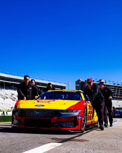 The No. 22 Ford of Joey Logano gets pushed to pit road.