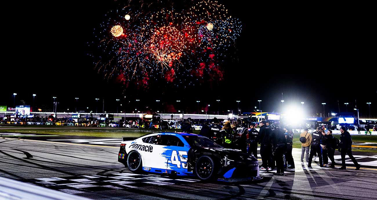 The No. 45 Toyota celebrates with fireworks in the distance after winning at EchoPark Speedway