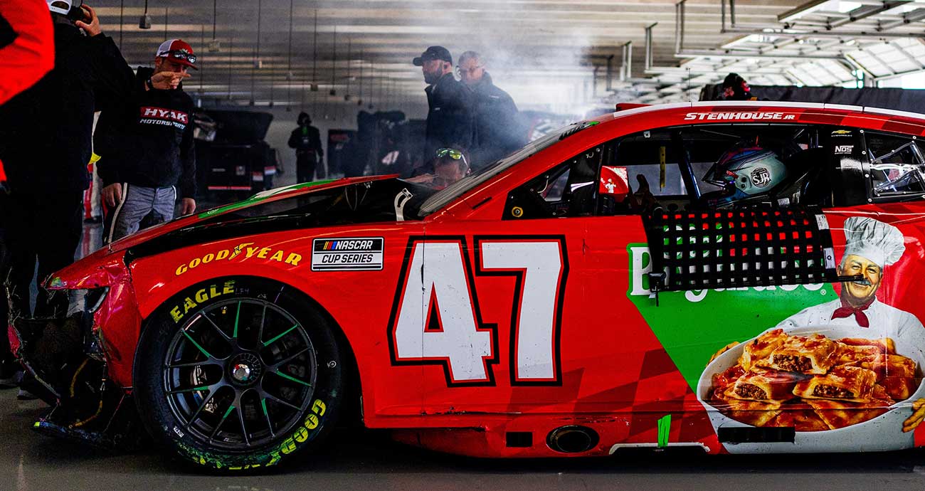 The damaged No. 47 Chevy of Ricky Stenhouse Jr. sits and steams in the Cup Series garage after a crash at EchoPark Speedway