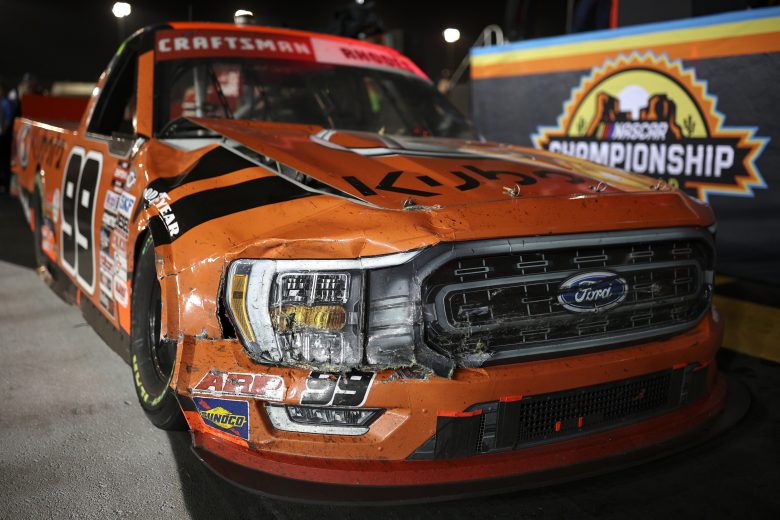 Vie of Ben Rhodes' with a bent truck hood in Victory Lane.