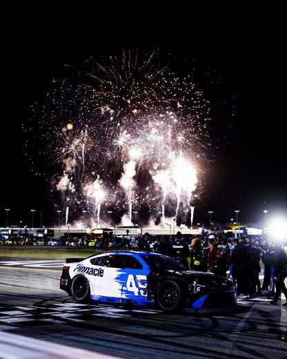 Fireworks go off in the background following Tyler Reddick's Cup Series victory at EchoPark Speedway.