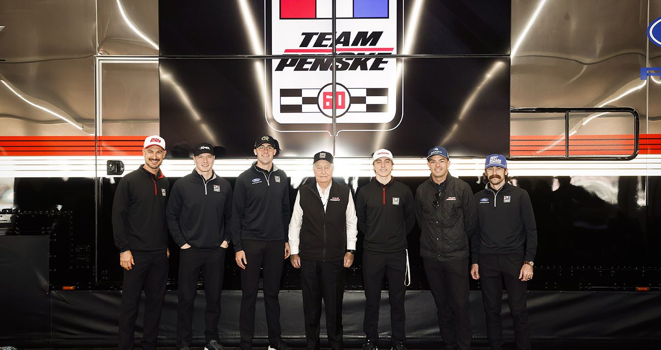 Roger Penske stands with both Cup Series and IndyCar drivers.