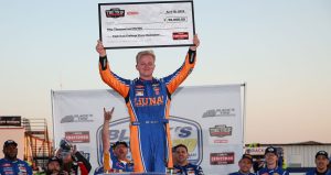 Tyler Ankrum poses for a photo with the Triple Truck Challenge check after winning a NASCAR Craftsman Truck Series race at Rockingham Speedway.