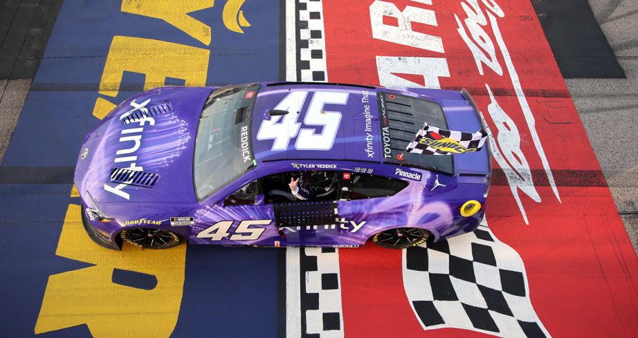 Tyler Reddick drives his No. 45 Toyota at Darlington Raceway with the checkered flag attached following his NASCAR Cup Series win at the track.