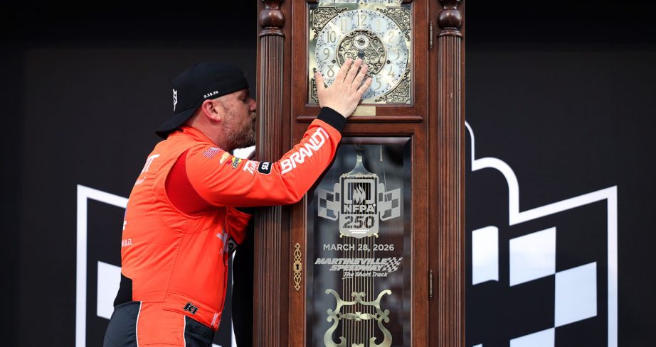 Justin Allgaier kisses the grandfather clock after his NASCAR O'Reilly Auto Parts Series win at Martinsville Speedway.
