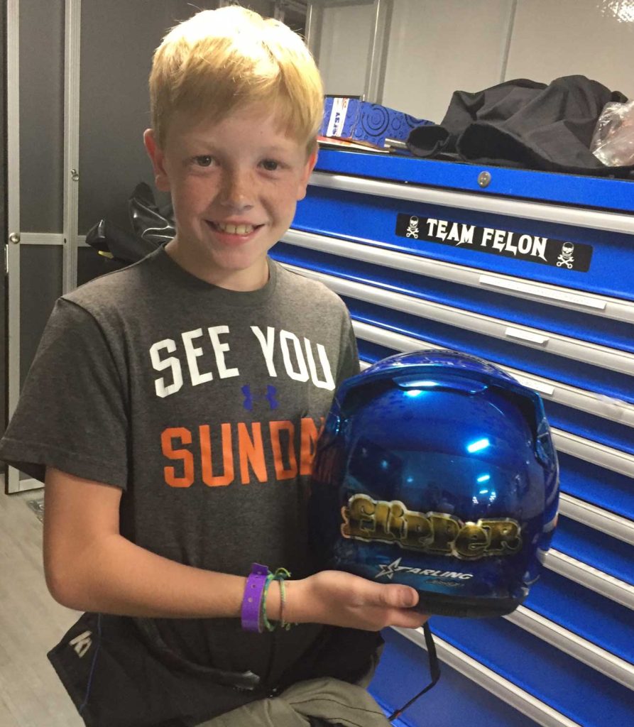 Connor Zilisch smiles, while holding a helmet