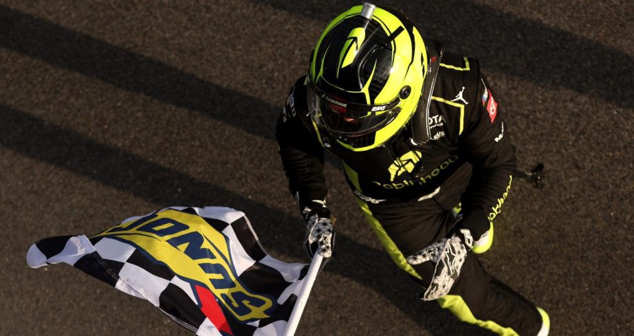Corey Heim holds checkered flag after win.