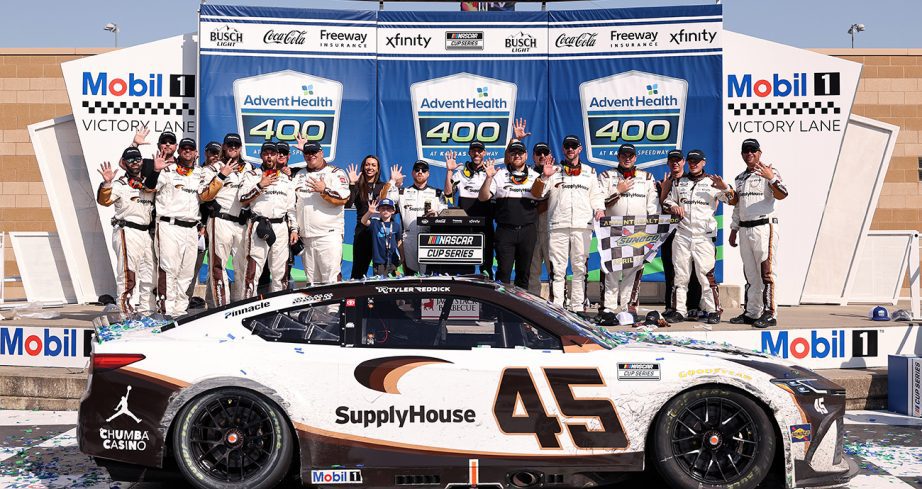 tyler reddick and crew celebrate in victory lane at kansas speedway