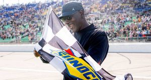 Michael Jordan celebrates with the checkered flag at Kansas Speedway