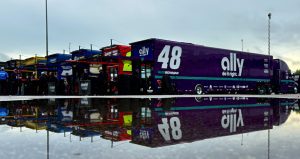 Haulers at Talladega are lined up with a massive puddle from rain in the foreground.