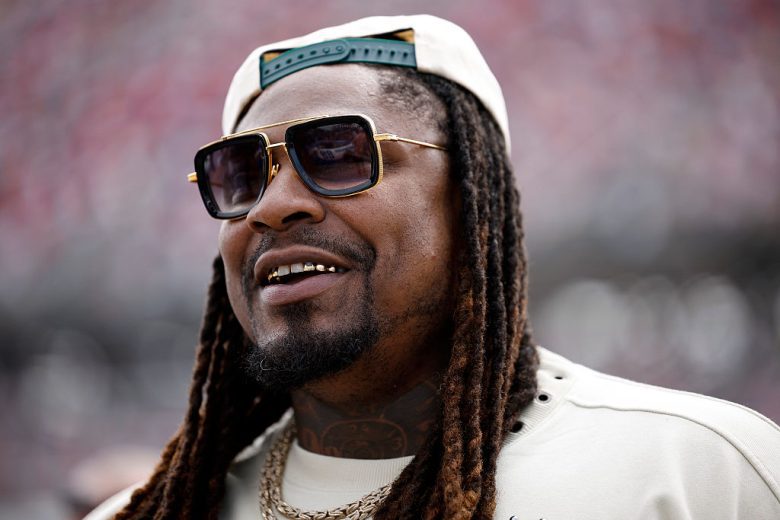 Marshawn Lynch looks on.