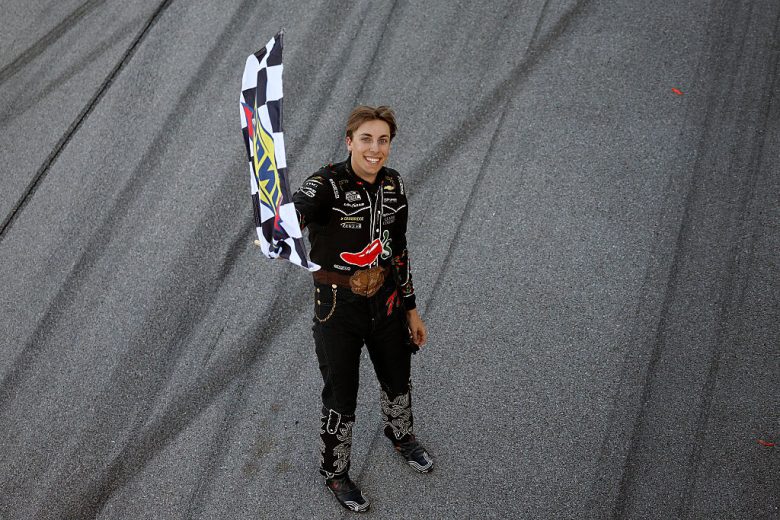 Carson Hocevar holds the checkered flag.