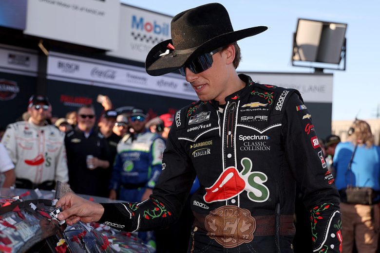 Carson Hocevar places the winner sticker on his No. 77 Chevrolet.