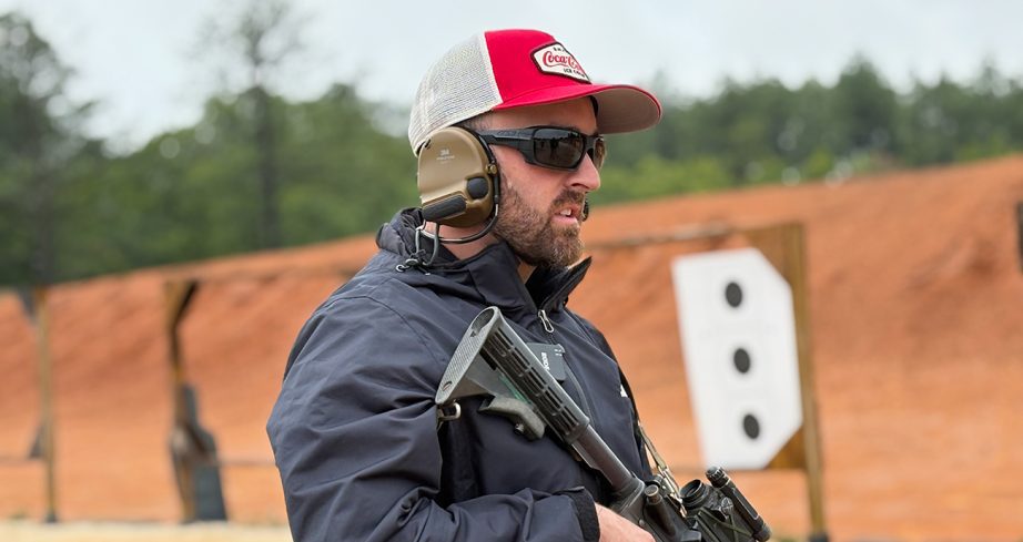 Austin Dillon gets ready to shoot a gun at Fort Bragg.