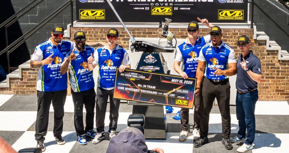 Pit crew poses trophy and check in VIctory Lane.