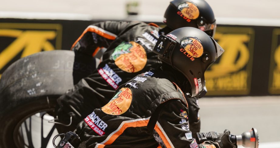 Pit crew members wait for car.