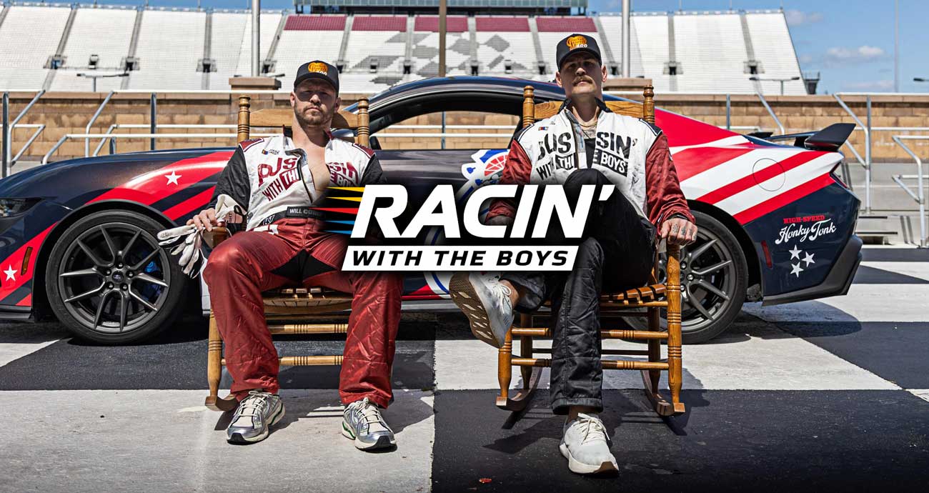 A staged photo of Taylor Lewin and Will Compton in front of a race car