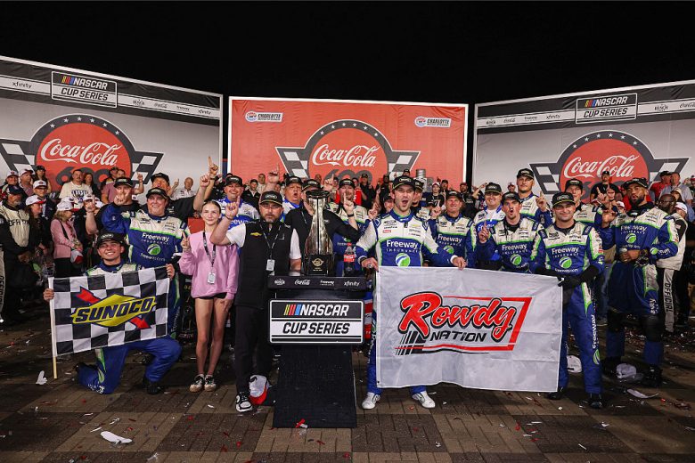 Daniel Suarez and the No. 7 team hold up a Kyle Busch Rowdy flag in Victory Lane.