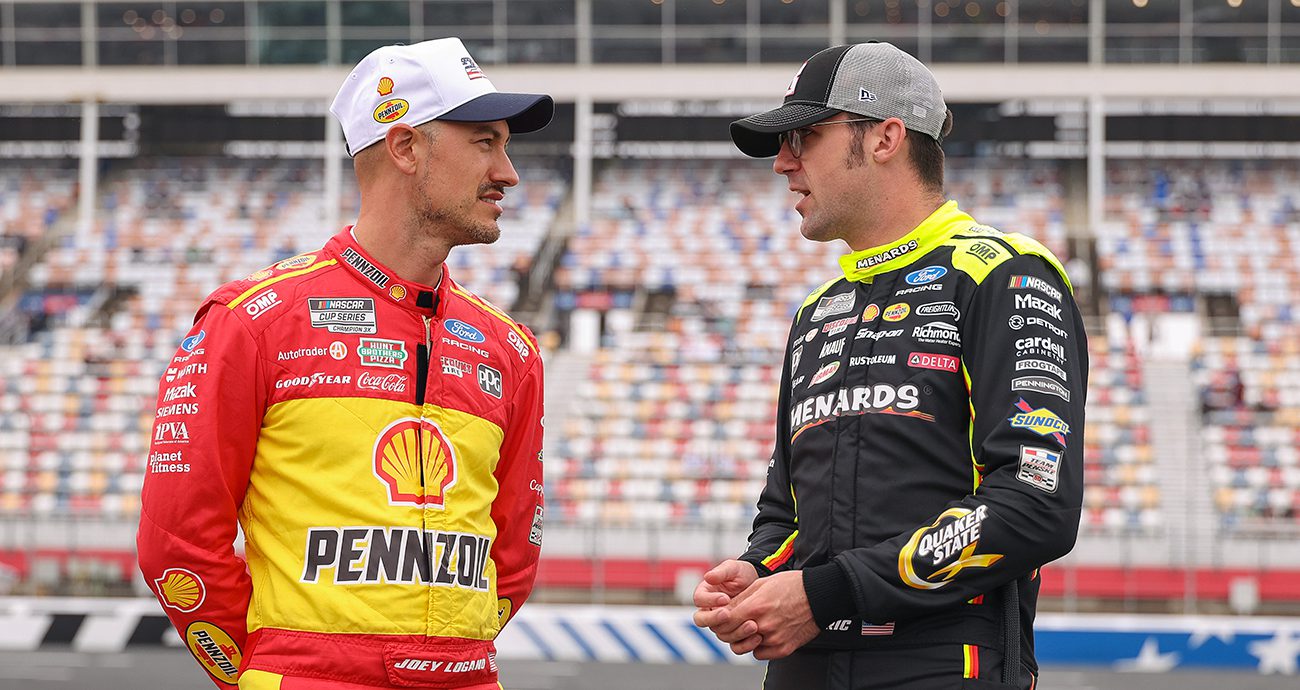 Joey Logano speaks with teammate Austin Cindric at Charlotte.