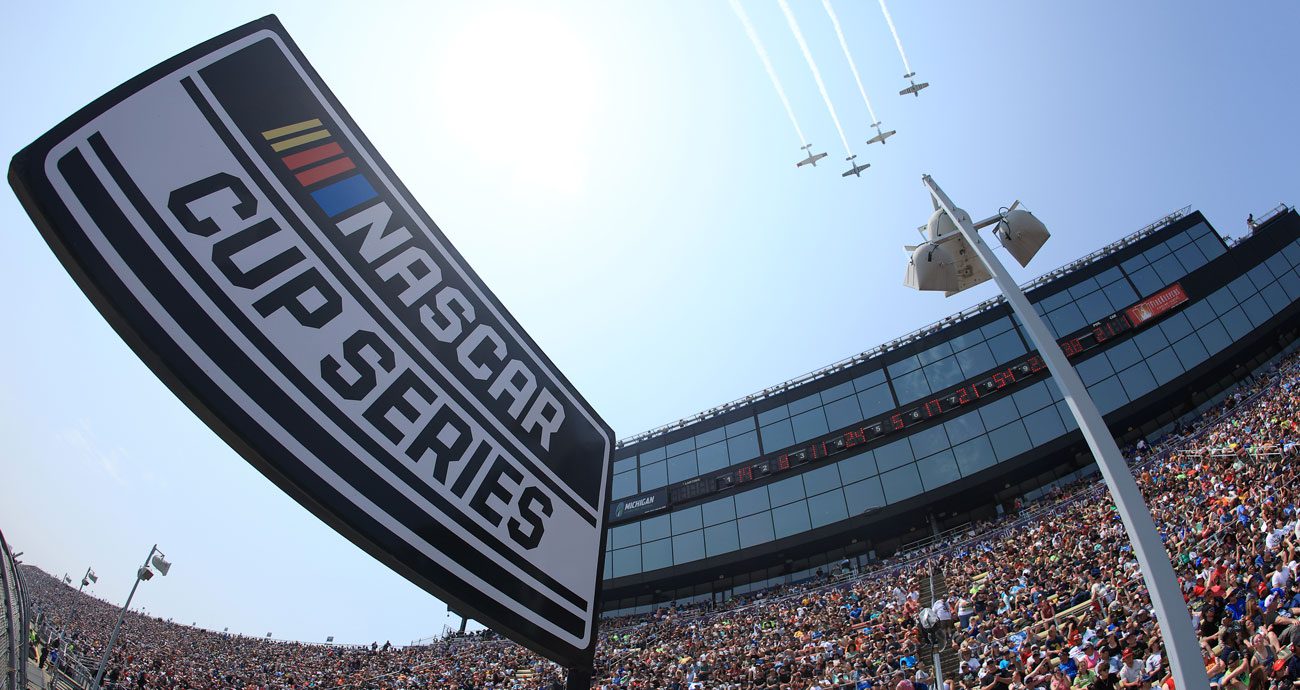 A NASCAR Cup Series badge hangs at Michigan during pre-race flyover on frontstretch.