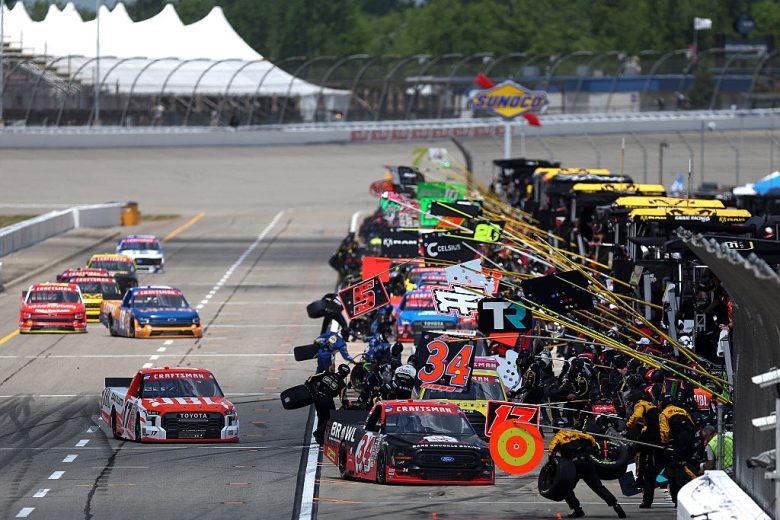 NASCAR Craftsman Truck Series trucks get tended to on pit road.