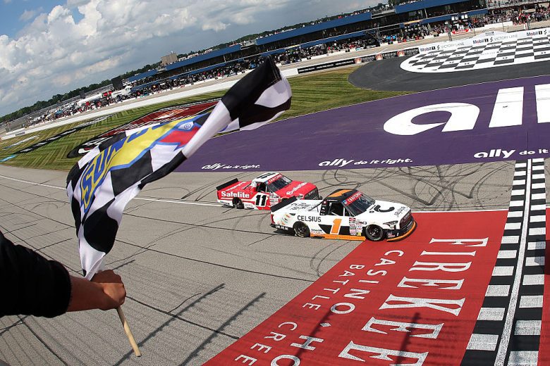 The checkered flag waves as Corey Heim, in the No. 1 Toyota, crosses the start/finish line at Michigan International Speedway.